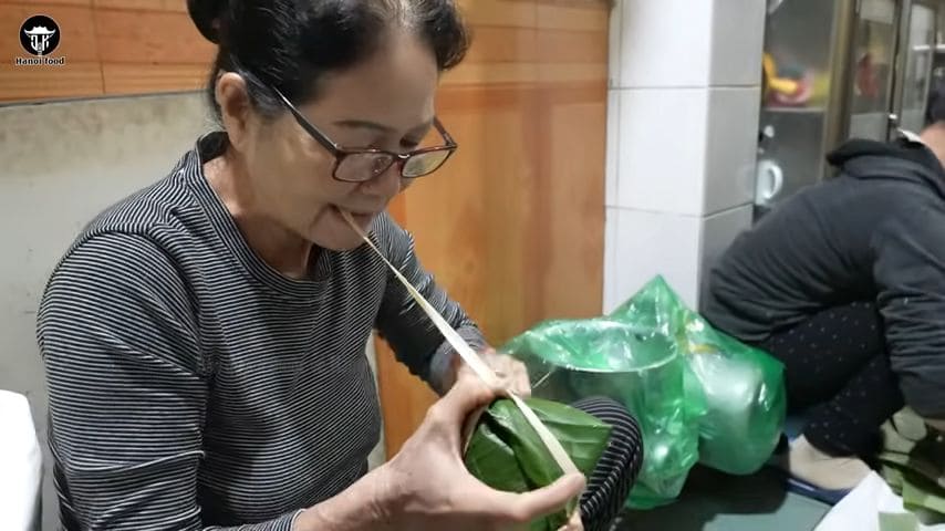 Tying bamboo strings for bánh giò