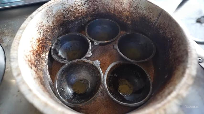 Blackened brass molds in sand pot for bánh thuẫn